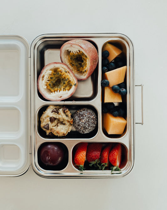 Stainless steel bento box with 5 compartments. Sustainable, eco-friendly, and zero plastic lunchbox alternative. Fruit salad and fresh baked and raw treats.